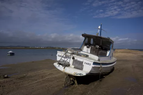 A boat at the beach of Faro, Portugal, during low tide A boat at the beach of Faro, Portugal, during low tide